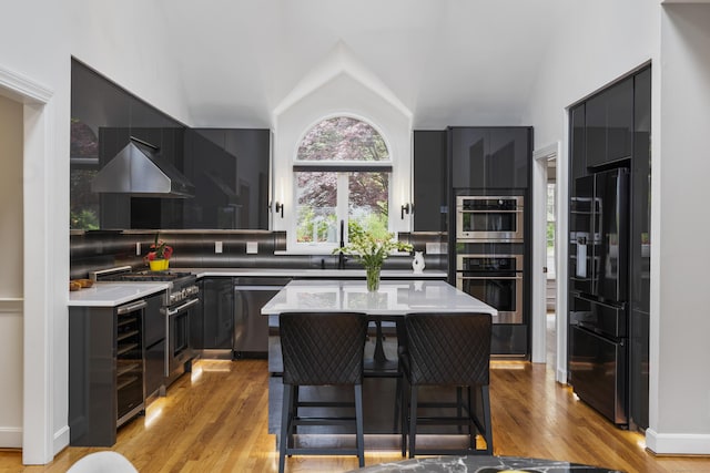 16 Whitehall Pl, Farmington, CT 06032 - kitchen featuring appliances with stainless steel finishes, beverage cooler, light wood-style flooring, light countertops, and lofted ceiling