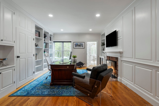 16 Whitehall Pl, Farmington, CT 06032 - living area featuring built in shelves, wood finished floors, recessed lighting, a glass covered fireplace, and a desk