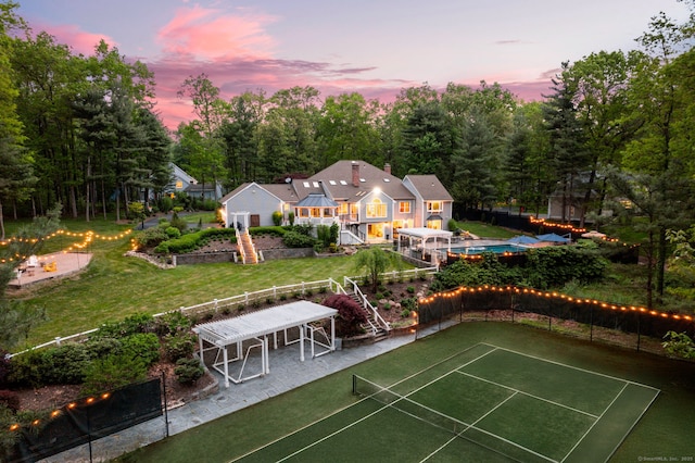 16 Whitehall Pl, Farmington, CT 06032 - back of house at dusk with a tennis court and stairway