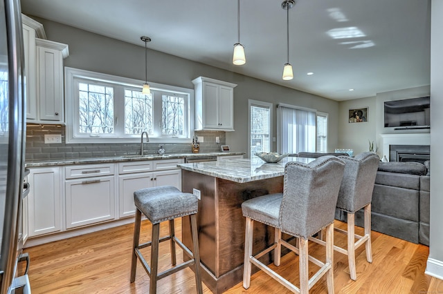 40 Newbury Ct Unit 40, North Haven, CT 06473 - kitchen featuring open floor plan, a kitchen bar, a center island, tasteful backsplash, and white cabinets