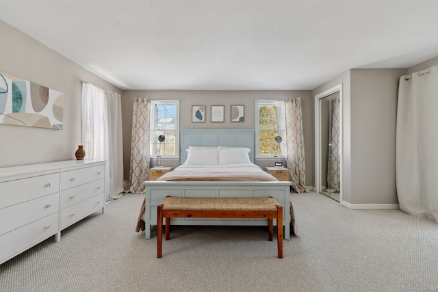 bedroom featuring baseboards, a textured ceiling, and light colored carpet