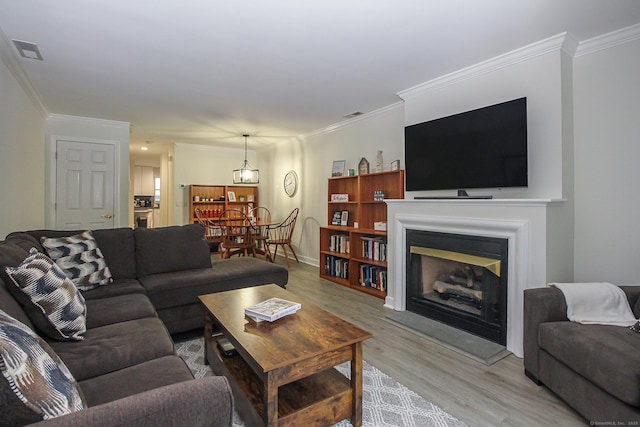 living room featuring hardwood / wood-style flooring and crown molding