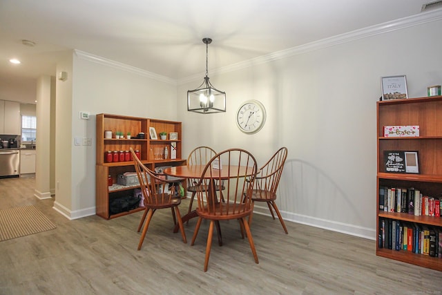 dining space featuring light wood-type flooring and ornamental molding