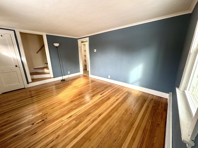 unfurnished bedroom featuring baseboards, ornamental molding, and wood finished floors