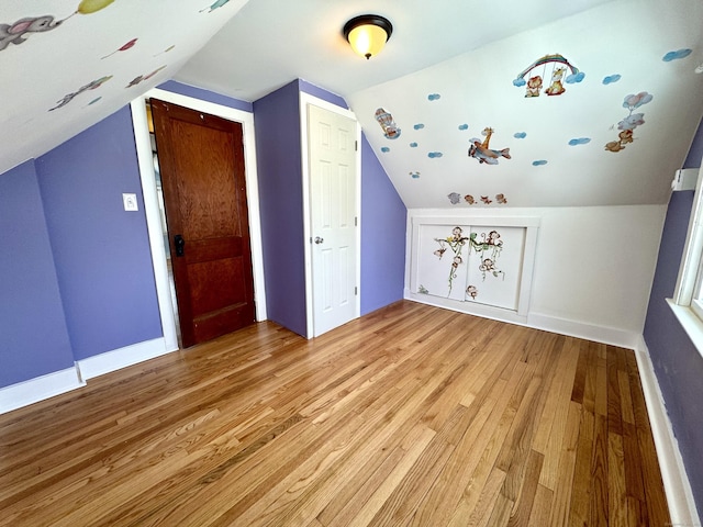 bonus room featuring light wood-style floors, lofted ceiling, and baseboards