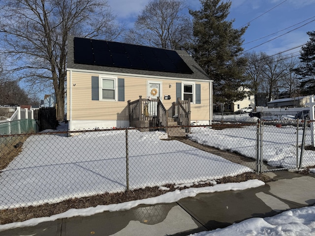 view of front facade featuring roof mounted solar panels and fence