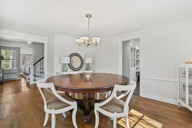 dining area featuring crown molding, radiator, wood finished floors, a chandelier, and stairs