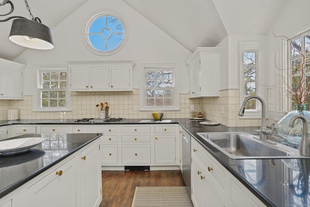 kitchen with dark countertops, white cabinetry, dark wood-style flooring, and a sink