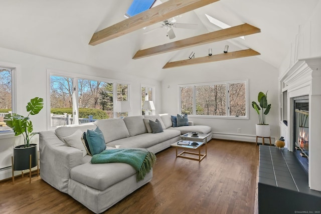 sunroom / solarium featuring a baseboard heating unit, a glass covered fireplace, and a wealth of natural light