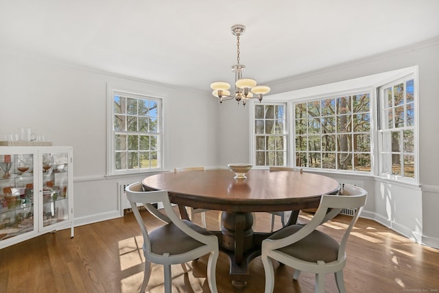 dining space with a notable chandelier, baseboards, and wood finished floors