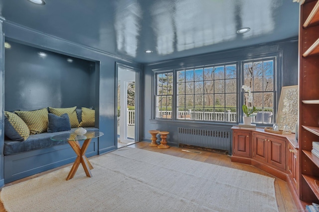 sitting room featuring radiator heating unit, wood finished floors, and recessed lighting