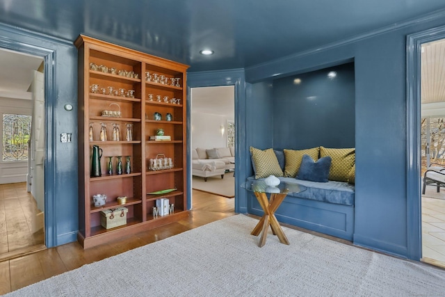 living area featuring crown molding and wood finished floors