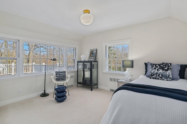 carpeted bedroom featuring radiator heating unit, baseboards, and vaulted ceiling