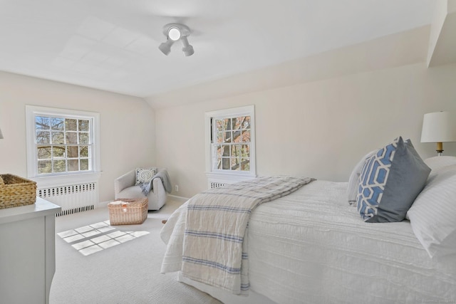 bedroom with radiator, carpet floors, and vaulted ceiling