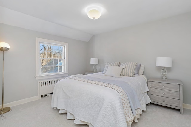 bedroom featuring lofted ceiling, baseboards, light carpet, and radiator heating unit