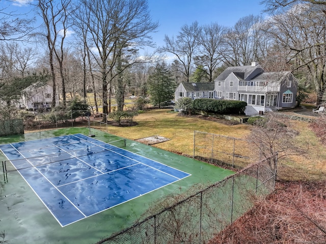 view of sport court featuring a yard and fence