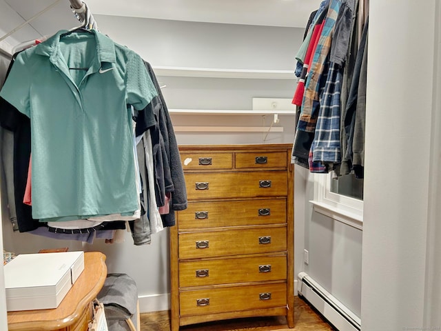 walk in closet featuring baseboard heating and wood finished floors