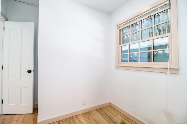 empty room featuring wood finished floors and baseboards