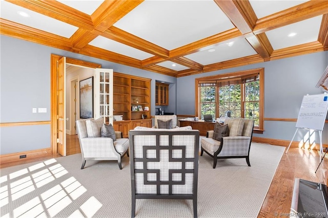 living room with beam ceiling, ornamental molding, light wood-type flooring, and coffered ceiling