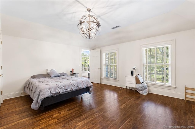 bedroom featuring an inviting chandelier and dark hardwood / wood-style floors