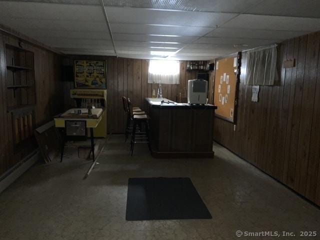 bar featuring a paneled ceiling and wood walls