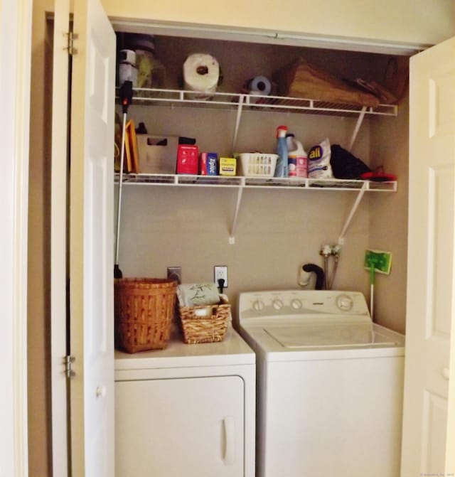 clothes washing area featuring washing machine and clothes dryer and laundry area
