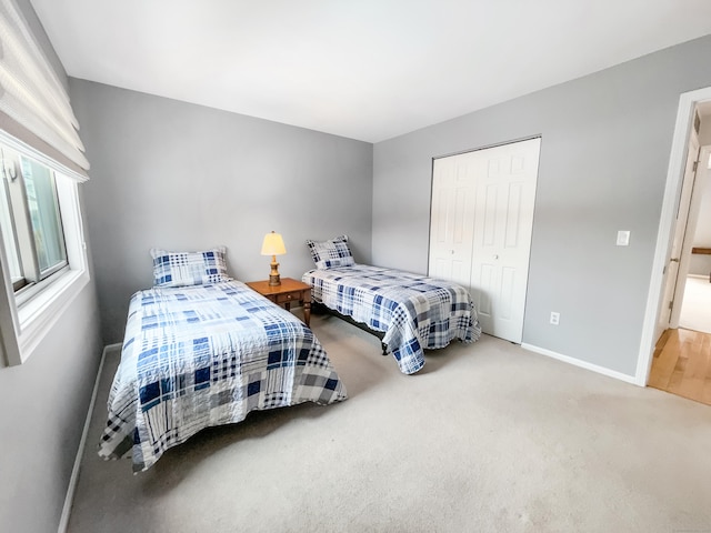 bedroom with carpet flooring, baseboards, and a closet