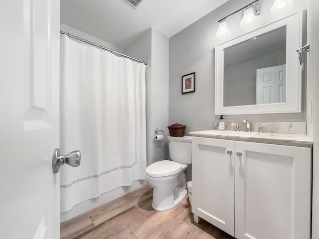 full bath featuring toilet, curtained shower, wood finished floors, and vanity