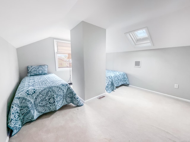 carpeted bedroom featuring baseboards, visible vents, and lofted ceiling with skylight