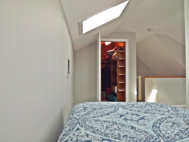bedroom with a closet, a spacious closet, visible vents, and lofted ceiling with skylight
