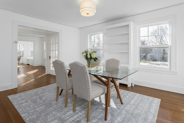 dining area featuring french doors, dark wood-type flooring, and baseboards