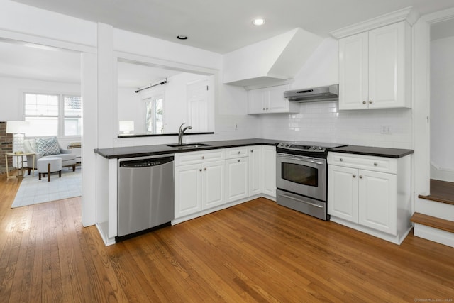 kitchen with appliances with stainless steel finishes, white cabinets, and under cabinet range hood