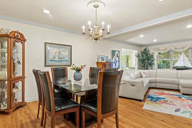 dining space featuring ornamental molding, light hardwood / wood-style flooring, and an inviting chandelier