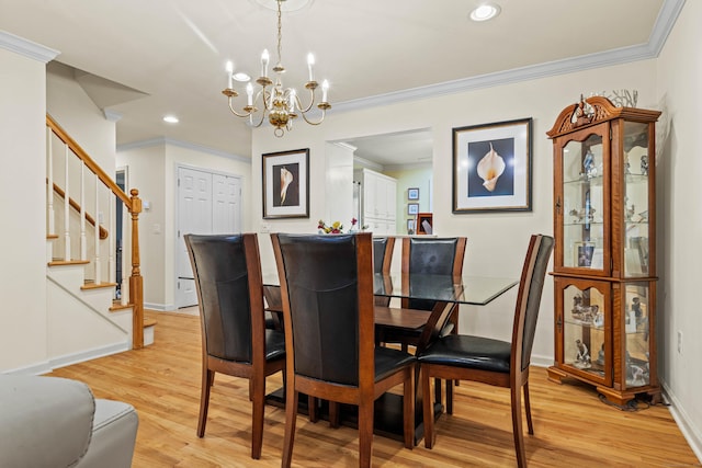 dining room with a notable chandelier, light wood-type flooring, and ornamental molding