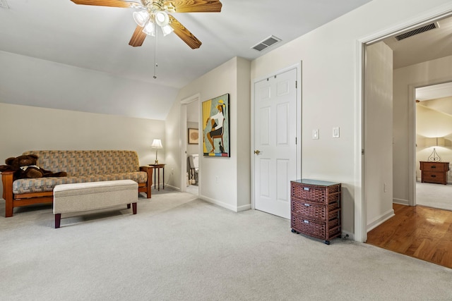 living area featuring light carpet, vaulted ceiling, and ceiling fan