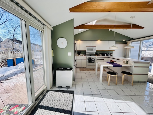 kitchen with light tile patterned floors, white microwave, electric range, white cabinets, and stainless steel refrigerator