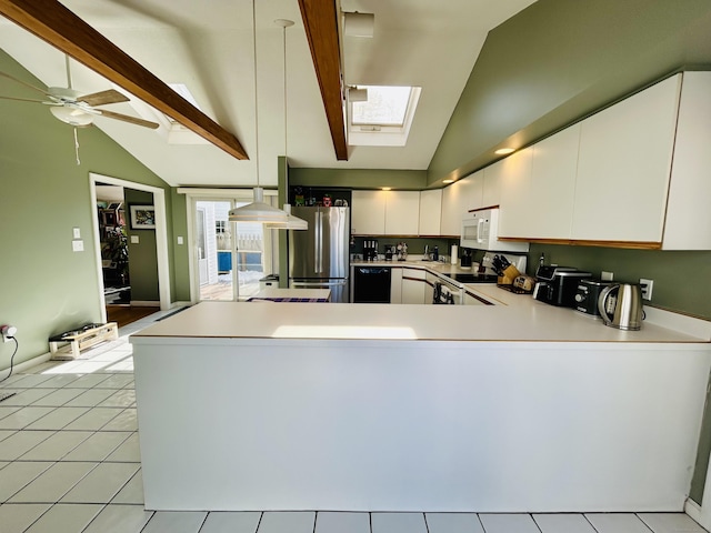 kitchen featuring light countertops, lofted ceiling with skylight, white cabinetry, white appliances, and a peninsula