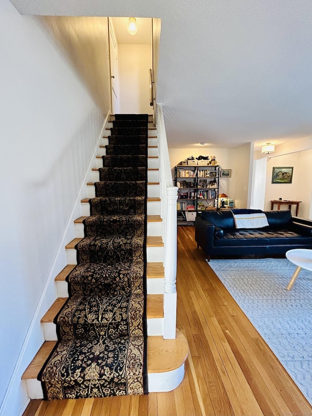 stairs with baseboards and hardwood / wood-style floors