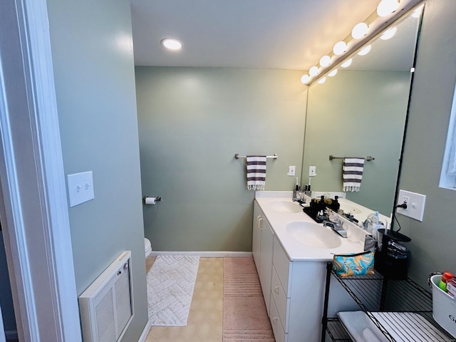 bathroom featuring double vanity, baseboards, visible vents, and a sink