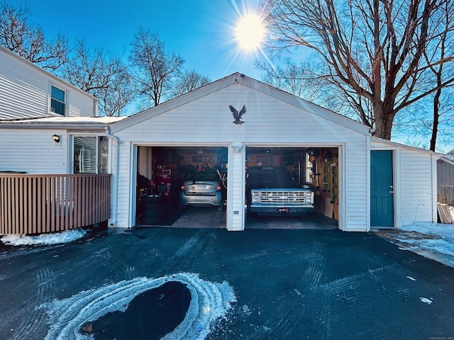 snow covered garage featuring driveway