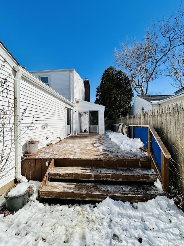 snow covered deck featuring fence