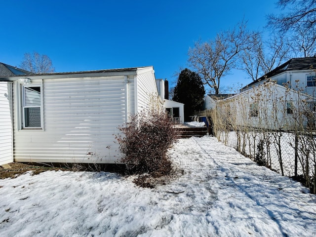 view of snow covered exterior featuring fence