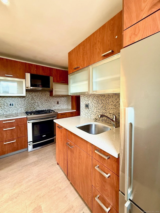 kitchen featuring light hardwood / wood-style floors, stainless steel appliances, backsplash, and sink