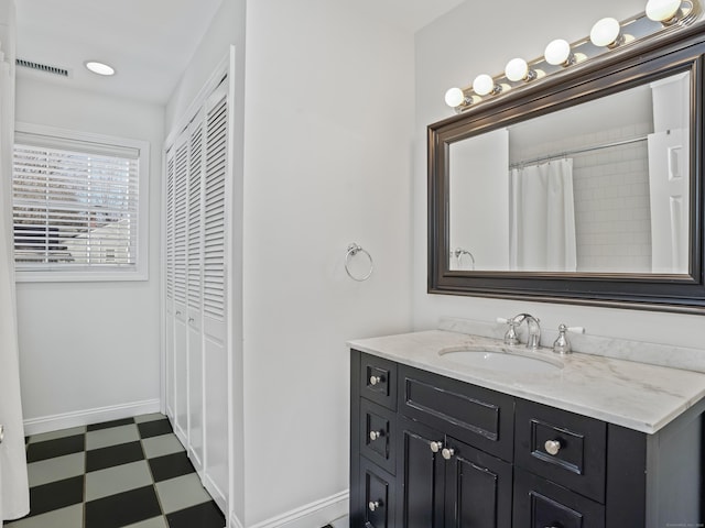 bathroom with baseboards, vanity, visible vents, and tile patterned floors