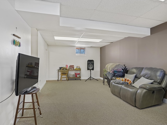 carpeted living area featuring baseboards and a drop ceiling