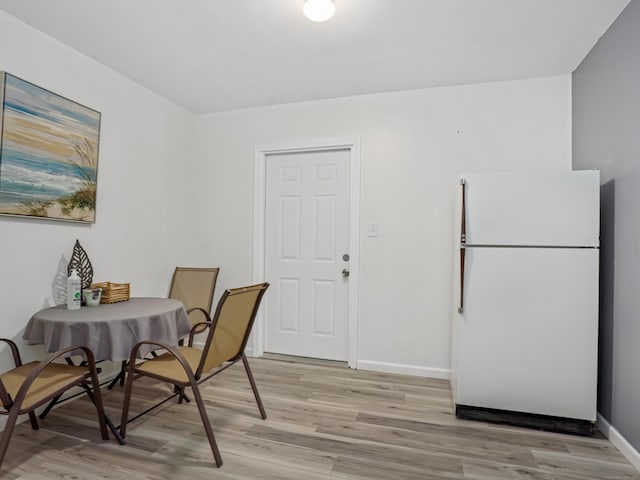 dining room with light wood-type flooring and baseboards