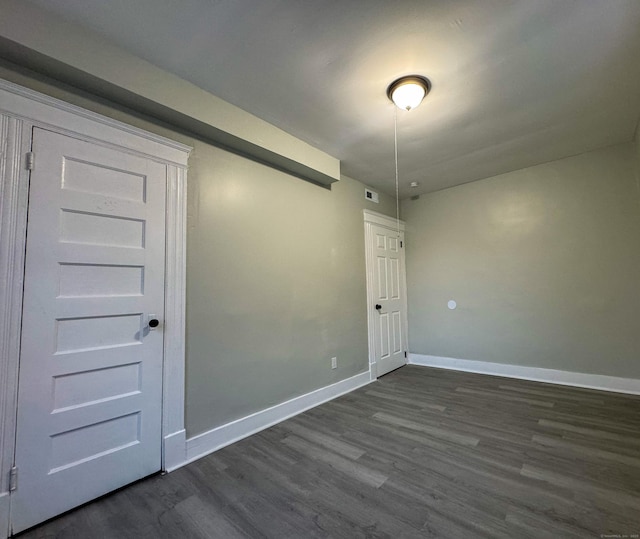 empty room with dark hardwood / wood-style flooring