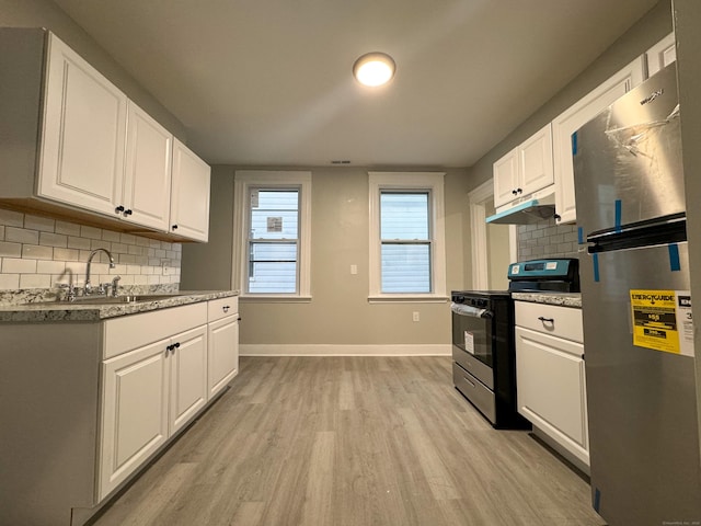 kitchen with light wood-type flooring, electric range oven, white cabinets, and stainless steel refrigerator