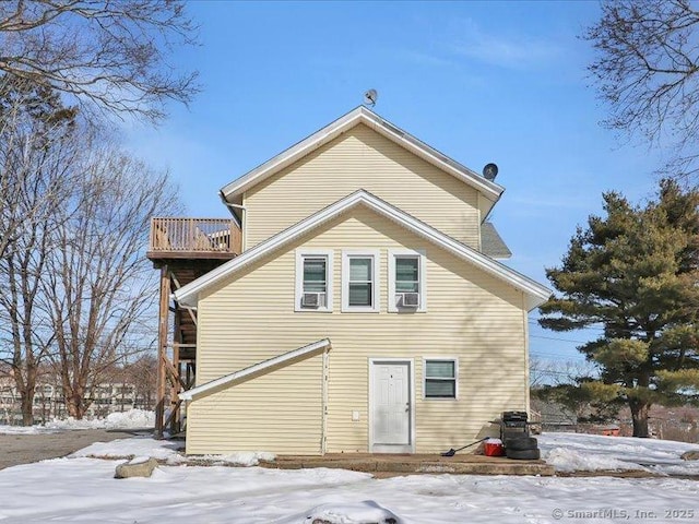 snow covered back of property with cooling unit