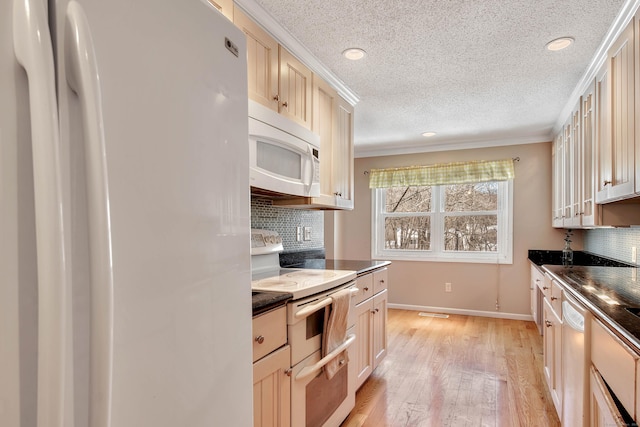 kitchen with white appliances, dark countertops, glass insert cabinets, light wood-type flooring, and backsplash